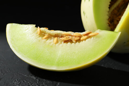 Fresh ripe honeydew melon on dark table, closeup