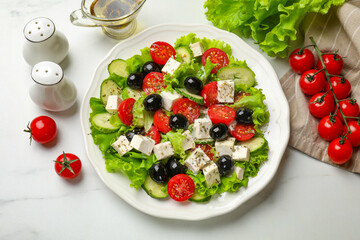 Delicious salad with feta cheese and ingredients on white table, flat lay