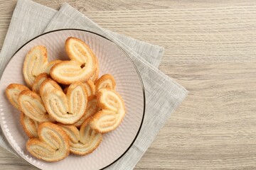 Delicious sweet palmier cookies on wooden table, top view