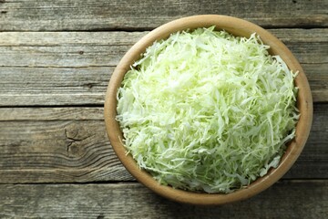 Fresh shredded cabbage on wooden table, top view. Space for text