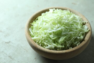 Fresh shredded cabbage on light table, closeup