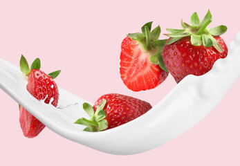 Strawberries and splashing milk or yogurt in air on pink background