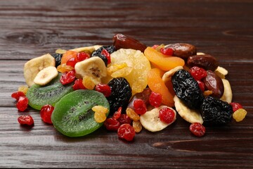 Mix of different dried fruits on wooden table, closeup