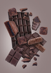 Different chocolate products in air on brown grey background
