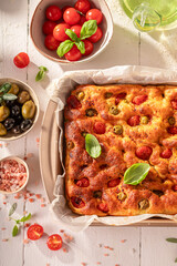 Hot focaccia with cherry tomatoes and green olives.