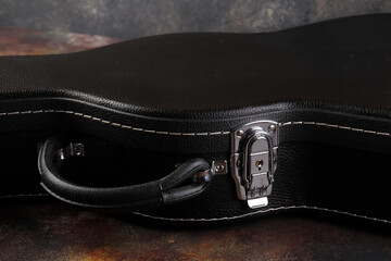 Old electric guitar against the background of a red concrete wall.
