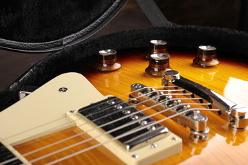 Old electric guitar against the background of a red concrete wall.