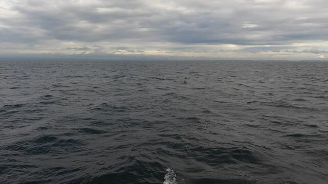 Ocean with waves, cloudy day, shooting in motion. Waves from the ship, horizon.