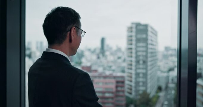 City, window and thinking in office, businessman and ideas for case, lawyer and professional in law firm. Contemplating, glass and planning for plea deal, legal and criminal defence attorney in Japan