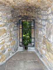Obraz premium Trieste, Italy - June 27, 2024: Historic San Giusto castle. Spot on ramparts where cannon stood, now empty and window now protected by metal grid 