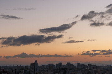 都市の夜明け。高層ビルをシルエットにあたりはオレンジ色に染まる