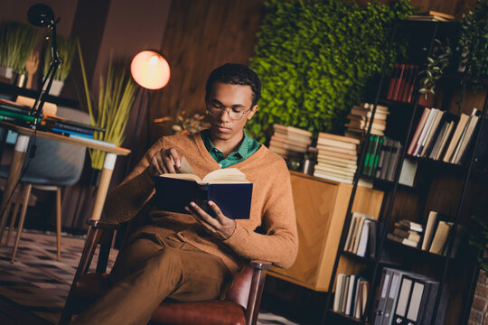 Young african american student studying indoors with focus and dedication in cozy apartment, surrounded by books and natural light
