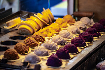 a vendor in the process of making hot and steaming wheel cakes