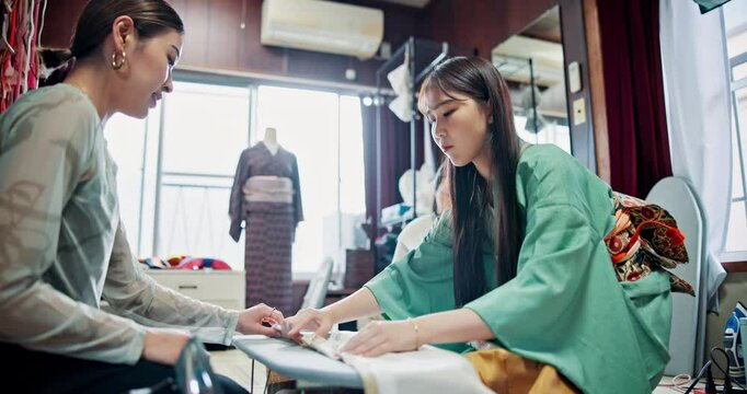 Asian women, fashion designer and fabric with garment for clothing production or apparel design at boutique store. Japan, female people or seamstress with material for kimono tradition or culture