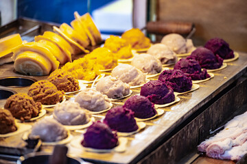 a vendor in the process of making hot and steaming wheel cakes