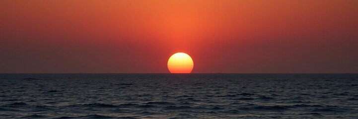 Majestic sun rises above the horizon casting a warm glow over the peaceful ocean, serene ocean scene, serenity