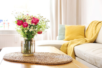 Naklejka premium Beautiful ranunculus flowers and chamomiles in vase on table indoors. Space for text