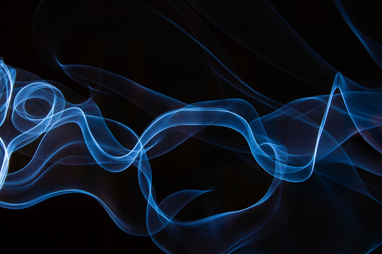 Photography of moving neon light with light trail on dark background, vibrant blue color