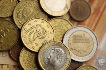 Many cent coins of euro currency lies on many fifty euro bills banknotes