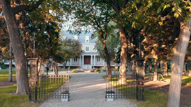 Walk to the old house, cinematic shooting. Old boarding house, beautiful building at sunset. White old building, old building with gates.