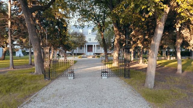 Walk to the old house, cinematic shooting. Old boarding house, beautiful building at sunset. White old building, old building with gates.