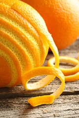 Fresh orange peel and fruits on wooden table, closeup