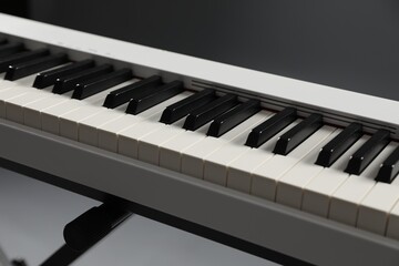 Synthesizer on grey background, closeup. Electronic musical instrument