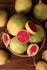 Whole and cut fresh turnips on wooden table, flat lay