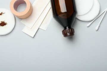 Topical iodine and other first aid kit components on light grey background, flat lay. Space for text
