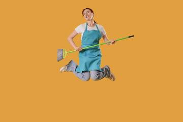 Female janitor with mop jumping on yellow background