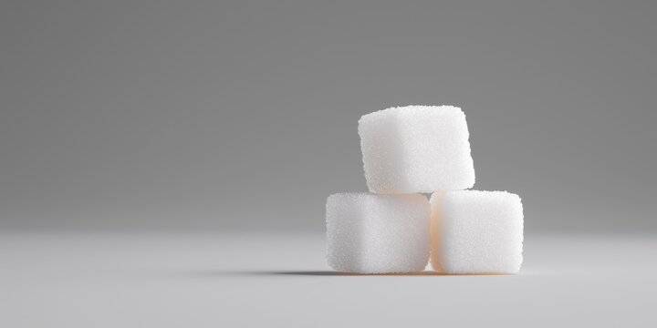 Three sugar cubes stacked neatly on a gray background.