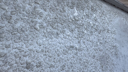 Close-up of condensation on a white wall surface