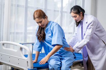 Fototapeta premium A woman in a blue hospital gown is being helped by a doctor