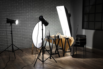 Interior of dark photo studio with professional equipment and table