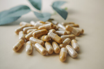 top view of herbal capsule supplement dropping on table 