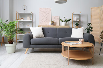 Interior of living room with sofa, table and shelf units