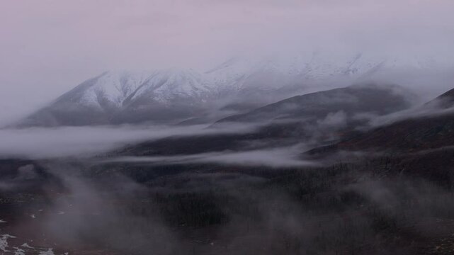 Snowy Ogilvie Mountains With Fog Clouds In Yukon Territory, Canada. wide shot