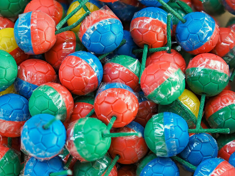 Vibrant Colorful Ball Firecrackers for Traditional Festive Celebrations.A top-down full-frame shot of a large pile of colorful ball firecrackers wrapped in bright red, blue, green, and yellow plastic 