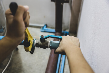 Plumber using a wrench to repair a water pipe. Concept of water pump maintenance fix water plumbing...