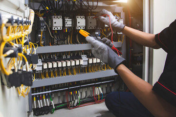 Electrical service technician holding electricity checking equipment to check electric current...