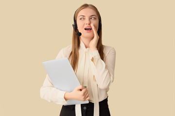 Female technical support agent in headset with laptop talking on beige background