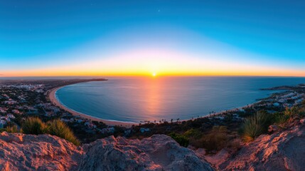 Fototapeta premium A beautiful sunset over the ocean with a beach in the background