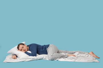Young man sleeping on blue background