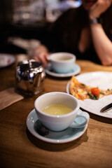 Cup of tea and a piece of pizza on the table in a cafe