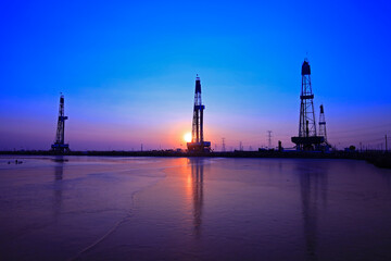 Fototapeta premium Sunset of oil drilling rig in the sea