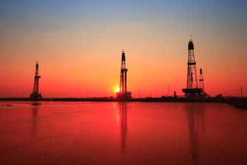 Obraz premium Sunset of oil drilling rig in the sea