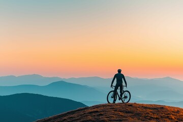 Obraz premium freedom movement and authentic, A cyclist stands on a hilltop, silhouetted against a colorful sunrise, surrounded by mountains and a serene landscape.