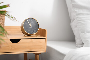 Alarm clock on table in light bedroom, closeup