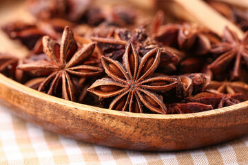 Wooden plate with aromatic star anise spice, closeup