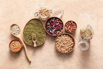 Composition with various raw legumes on color background
